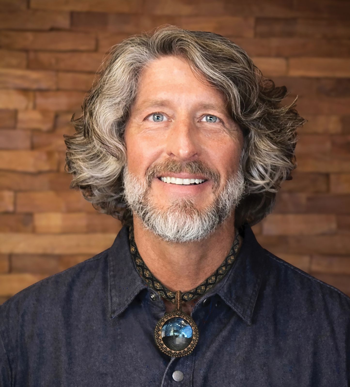Close-up headshot of Marc Buckley smiling against a brick wall